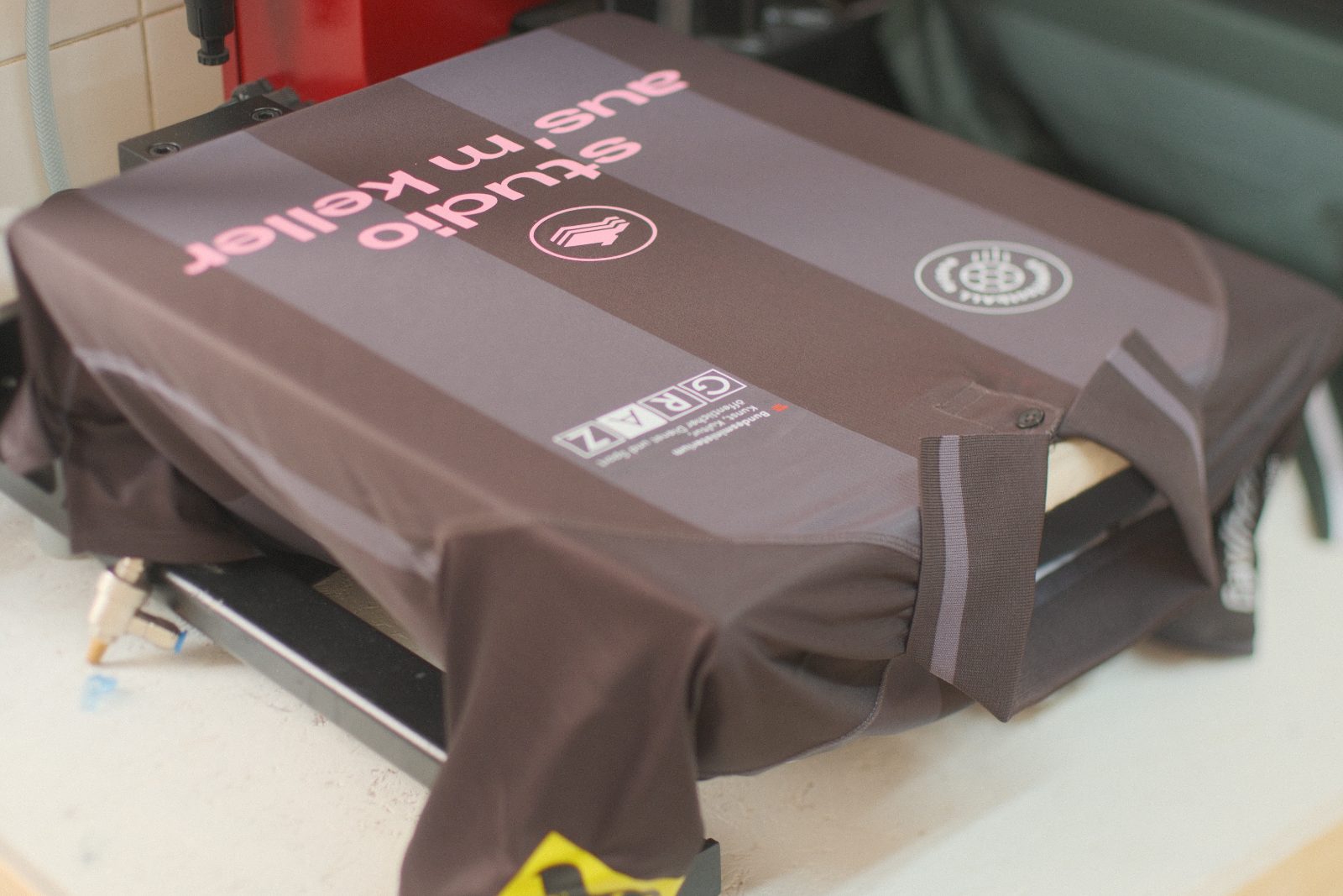 Grünes Fußballtrikot auf der Transferpresse, ausgerichtet über ein Laser-Fadenkreuz, mit „studio aus'm keller