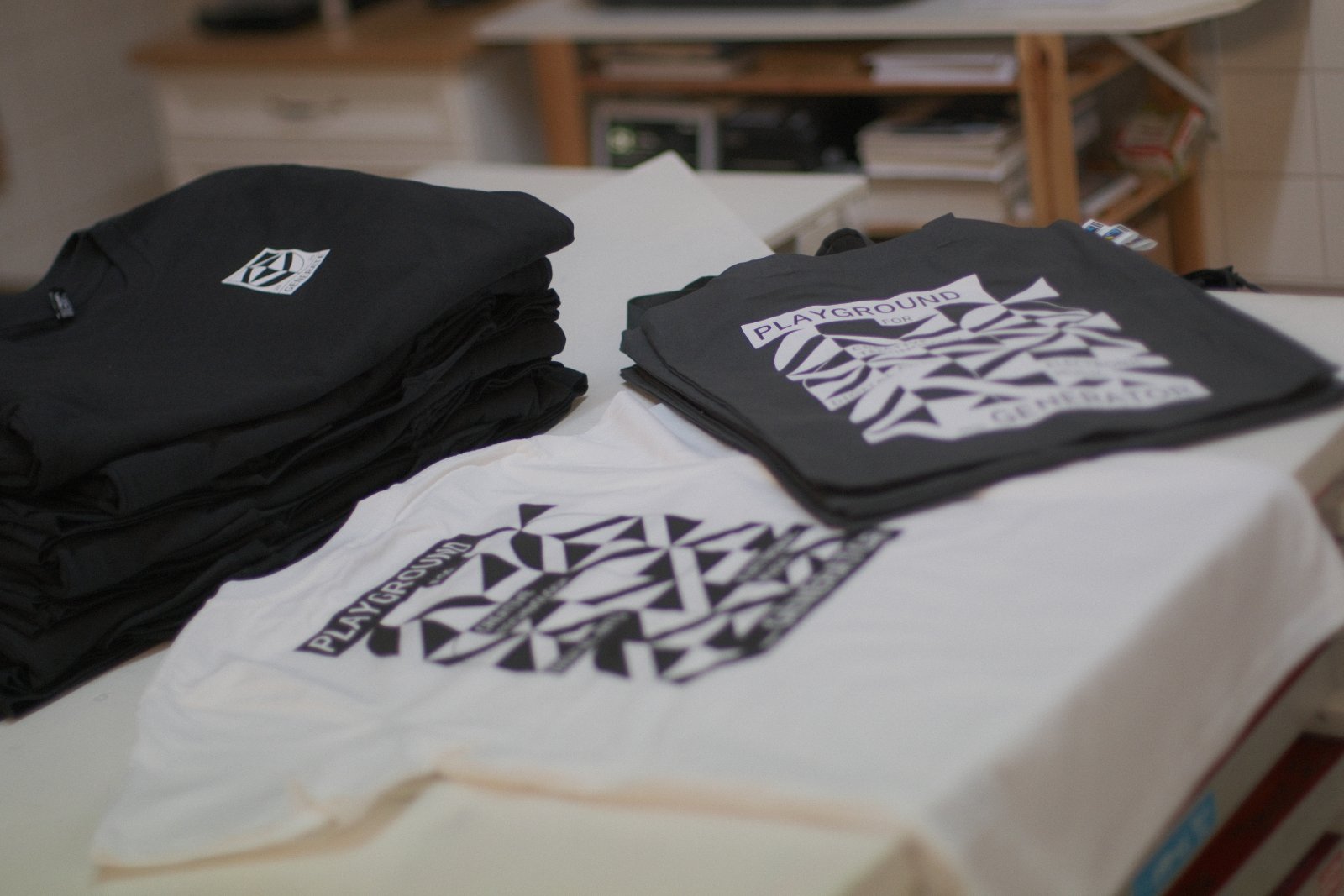 Generate26-Festival-Shirts in zwei Varianten — schwarz mit weißem Druck und naturweiß mit Algae-Black-Druck — Earth Positive Bio-Baumwolle