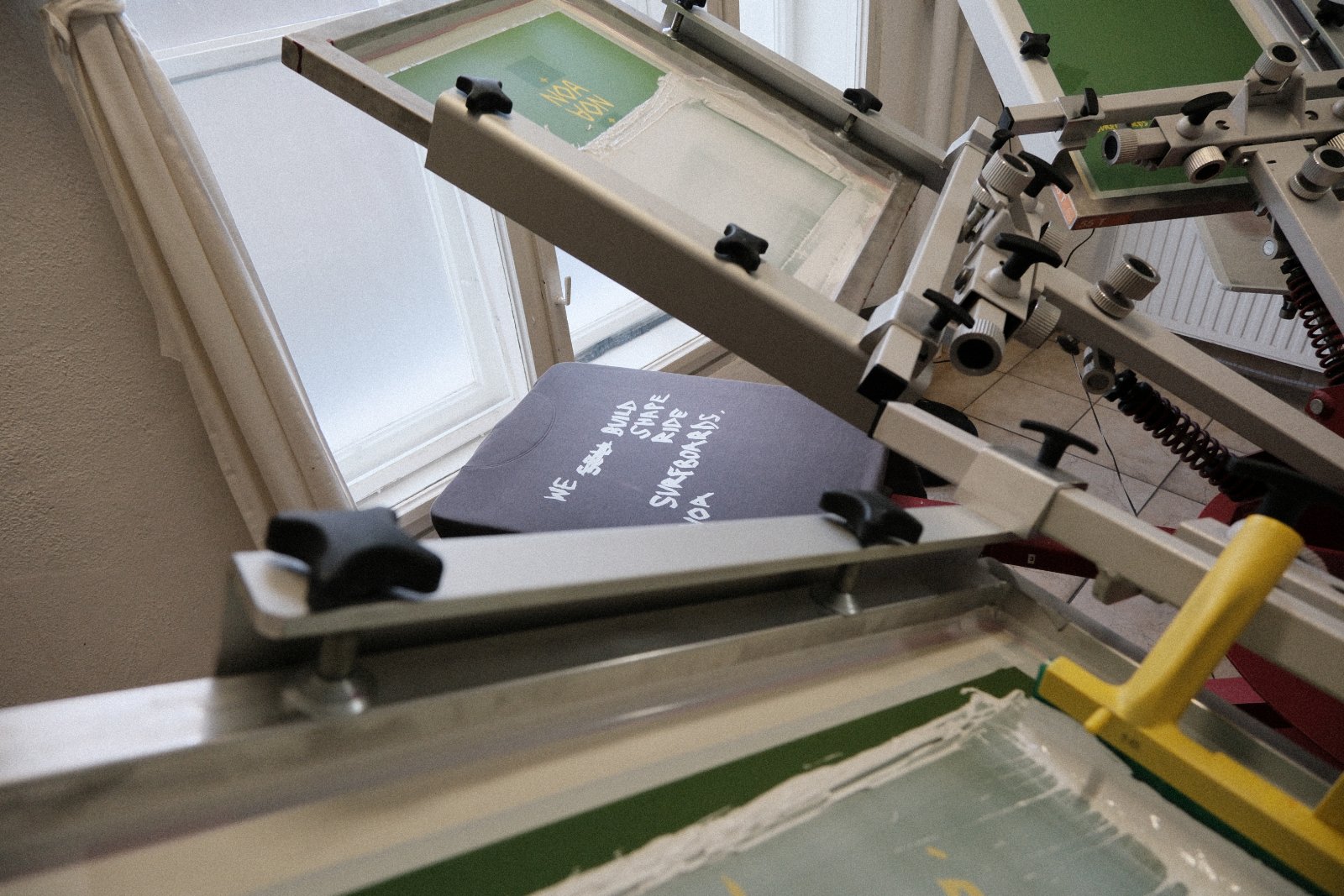 Druckvorgang am Handdruck-Karussell — NOA-Motiv wird auf weißes Earth-Positive-Shirt gedruckt
